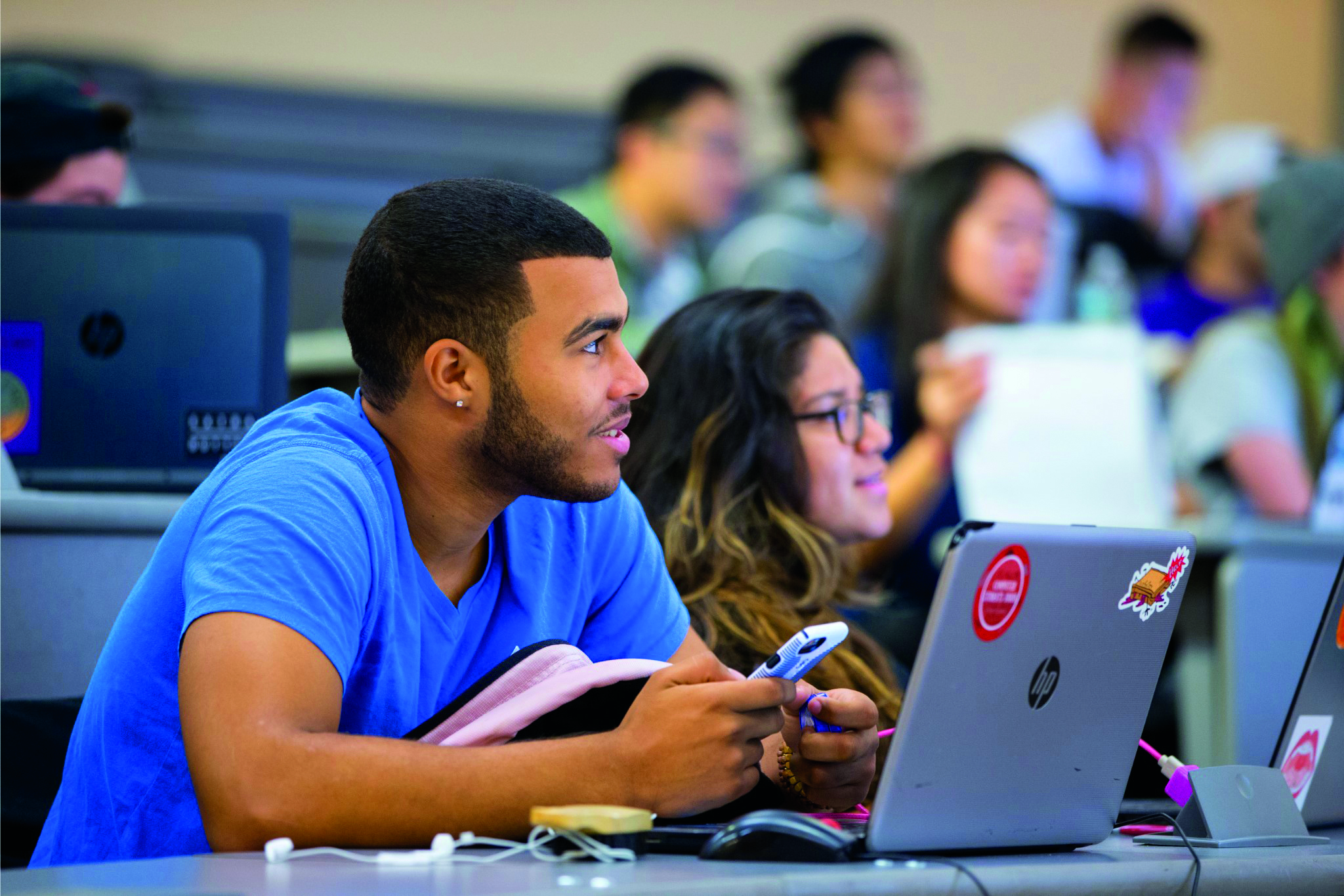 Students working together on laptops in a lecture hall
